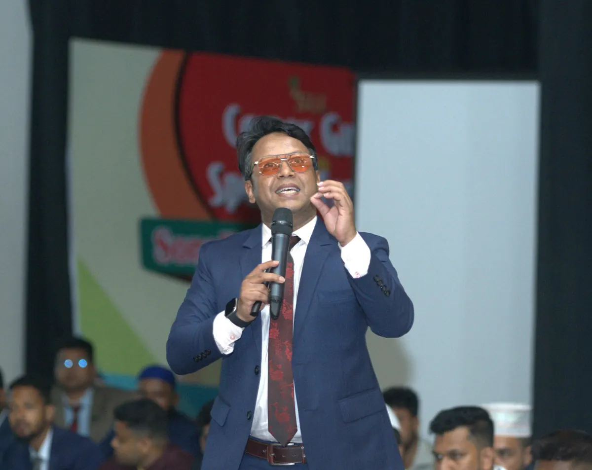 On stage in front of a standing audience at a corporate event